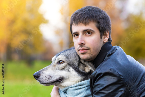 young happy man hugging dog. pet adoption.  czechoslovak with male owner. boy walking, playing, training Saarlos wolfdog in the park outdoors. soft focus photo