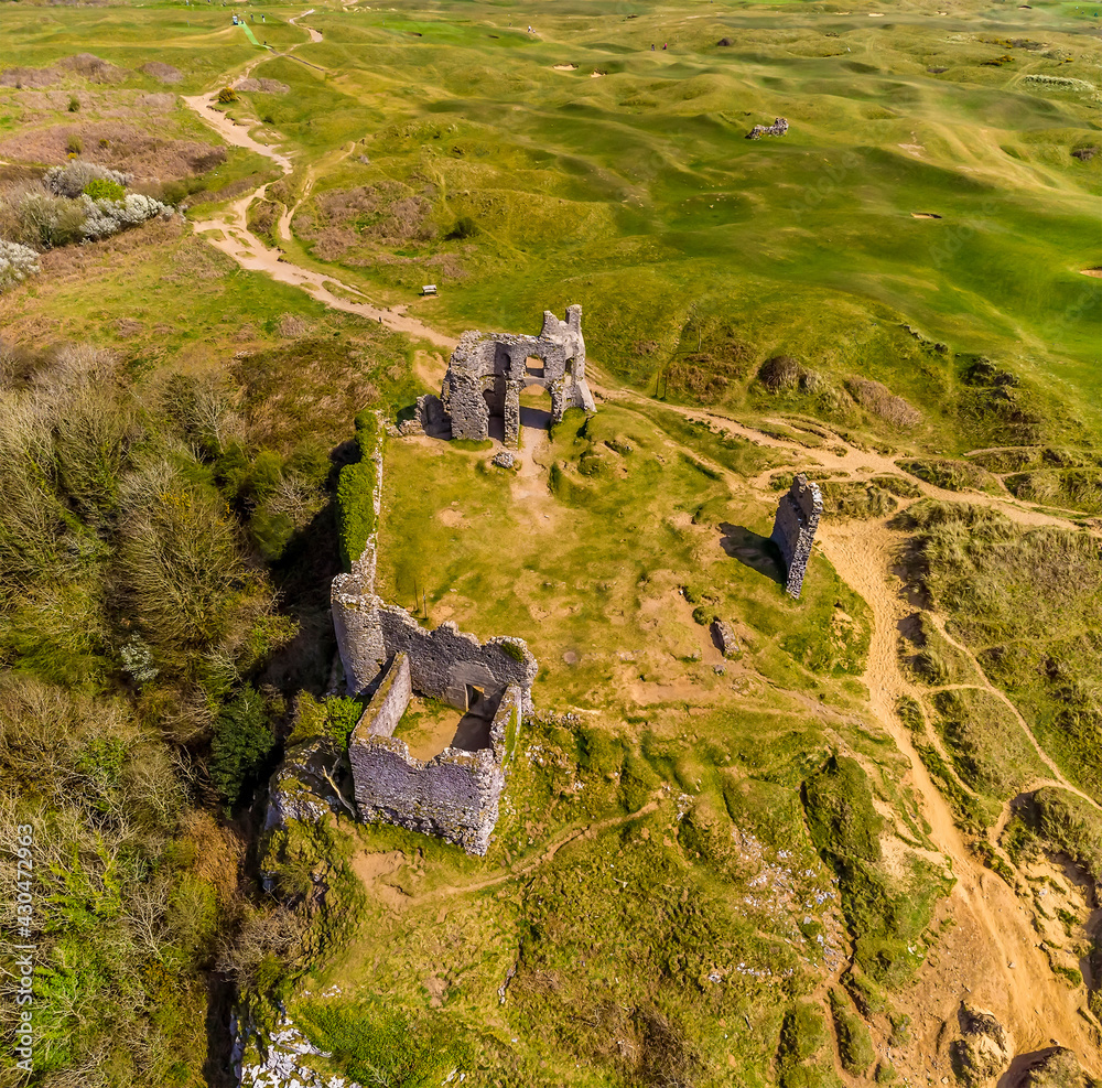 An aerial view above the castle ruins from the Three Cliffs Bay, Gower Peninsula, Swansea, South