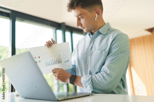 Cropped portrait of businessman working from home with laptop and diagram