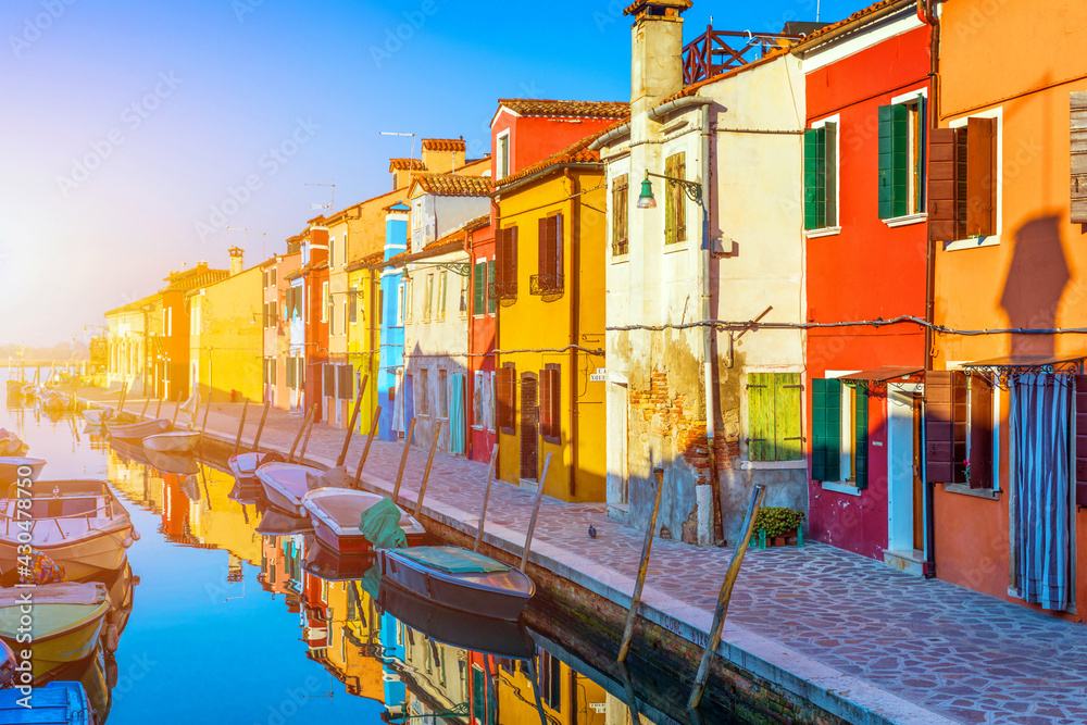 Obraz premium Street with colorful buildings in Burano island, Venice, Italy. Architecture and landmarks of Burano, Venice postcard. Scenic canal and colorful architecture in Burano island near Venice, Italy