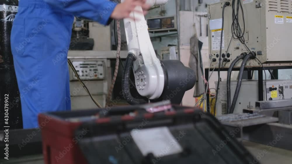 Factory worker woman or technician use tool to fix and maintenance part of robotic machine in workplace area then leave after finish work. Factory worker woman or technician use tool to fix and maintenance part of robotic machine in workplace area then leave after finish work.