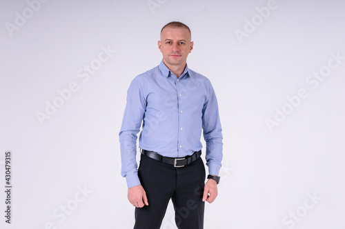 Man in blue shirt and black trousers on white background