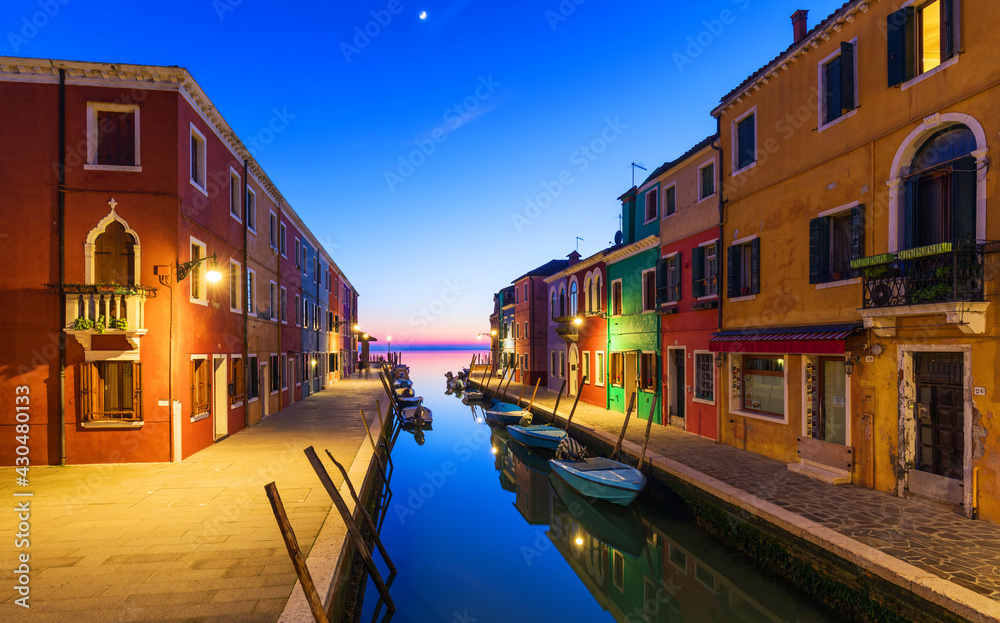 Colorful houses at night in Burano, Venice Italy. Night lights on the beautiful Burano island. Venice, Italy. Colourfully painted houses facade on Burano island in evening, province of Venice, Italy