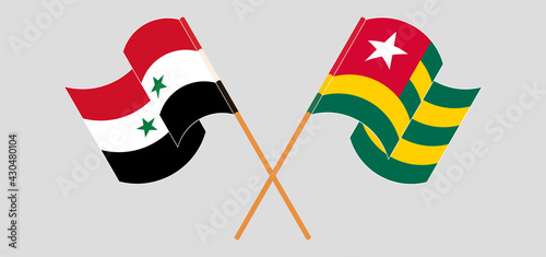 Crossed and waving flags of Syria and Togo