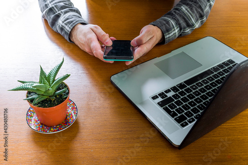 Man working at home from his computer on the living room table on a fantastic summer day photo