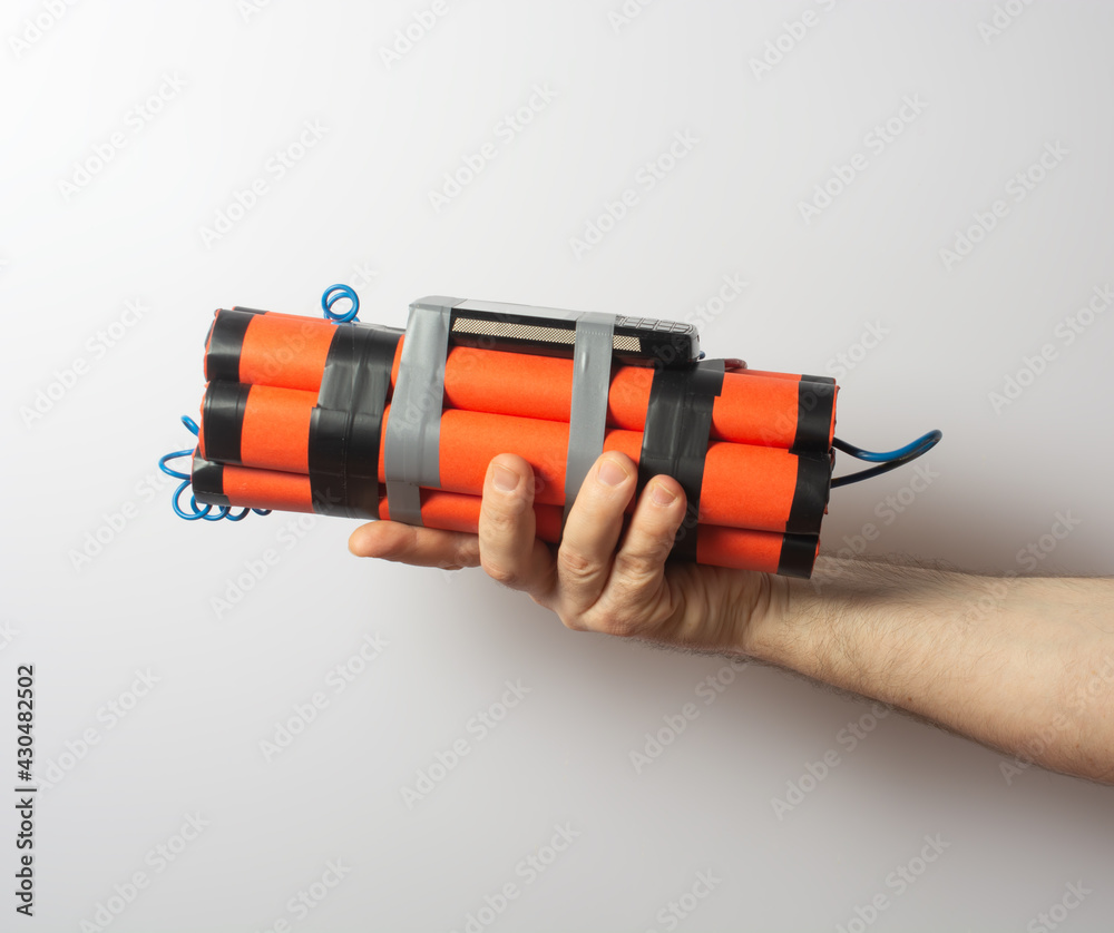 a man is holding a bomb with a timer made from a smartphone. survival and terrorism concept. a man is holding a bomb with a timer made from a smartphone. survival and terrorism concept.