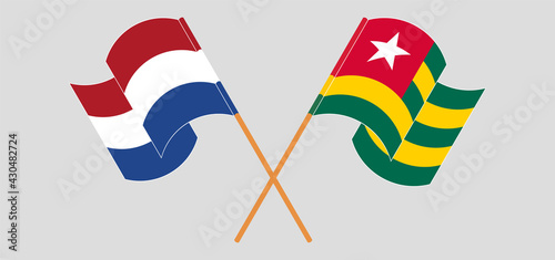 Crossed and waving flags of the Netherlands and Togo