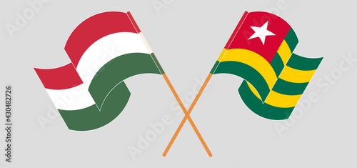 Crossed and waving flags of Hungary and Togo