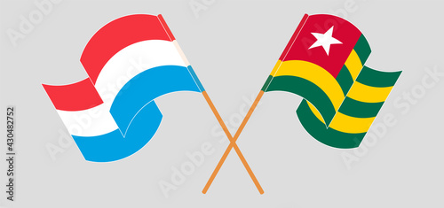 Crossed and waving flags of Luxembourg and Togo