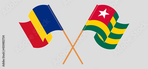 Crossed and waving flags of Romania and Togo