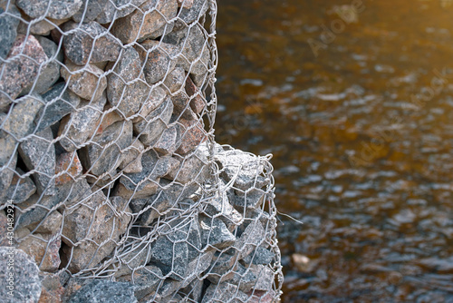 Gabion and rock armour - coastal and waterways protection. Gabion walls constructed using steel wire mesh basket. Stone wall, gabion revetment - protection from backshore erosion. photo