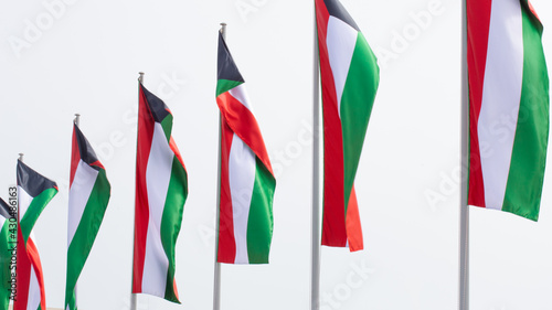 Multiple Kuwait national flags flying during the day at an event in Doha, Qatar