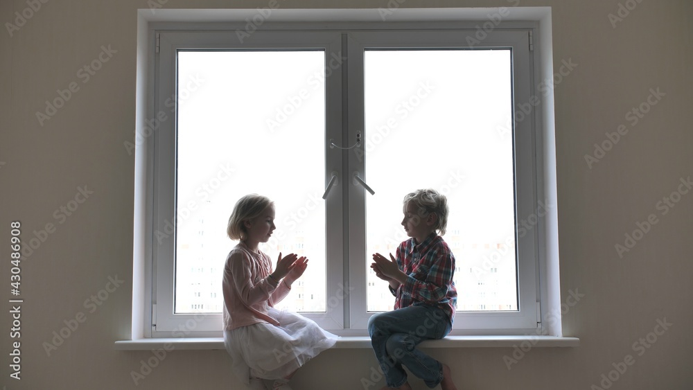 Silhouette of children playing hand on window sill. Silhouette of children playing hand on window sill.