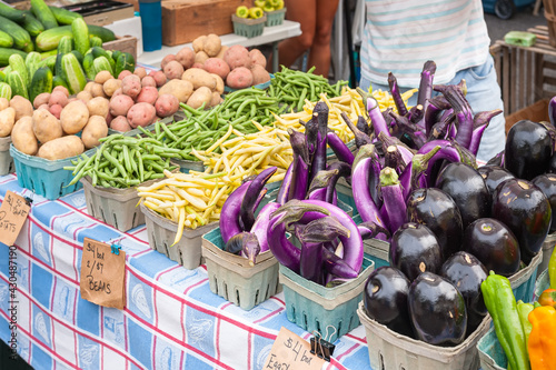 Tableau sur toile A bounty of vegetables at the market including cucumbers, potatoes, beans, and various eggplants