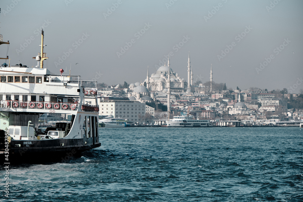 Fototapeta premium Turkey istanbul 03.03.2021. Pedestrian ferry with magnificent istanbul city and grand mosques established by ottoman empire background during early in the morning 