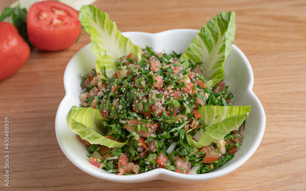 A bowl of delicious fresh Tabbouleh (tabbouli) salad with parsley, mint, tomato, onion, olive oil and lemon juice. A bowl of delicious fresh Tabbouleh (tabbouli) salad with parsley, mint, tomato, onion, olive oil and lemon juice.