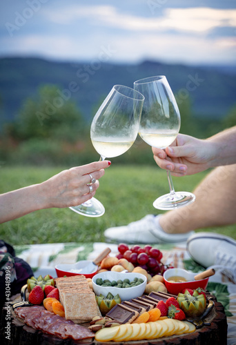 young couple having picnic and toasting with champagne in nature in vale dos vinhedos brazil