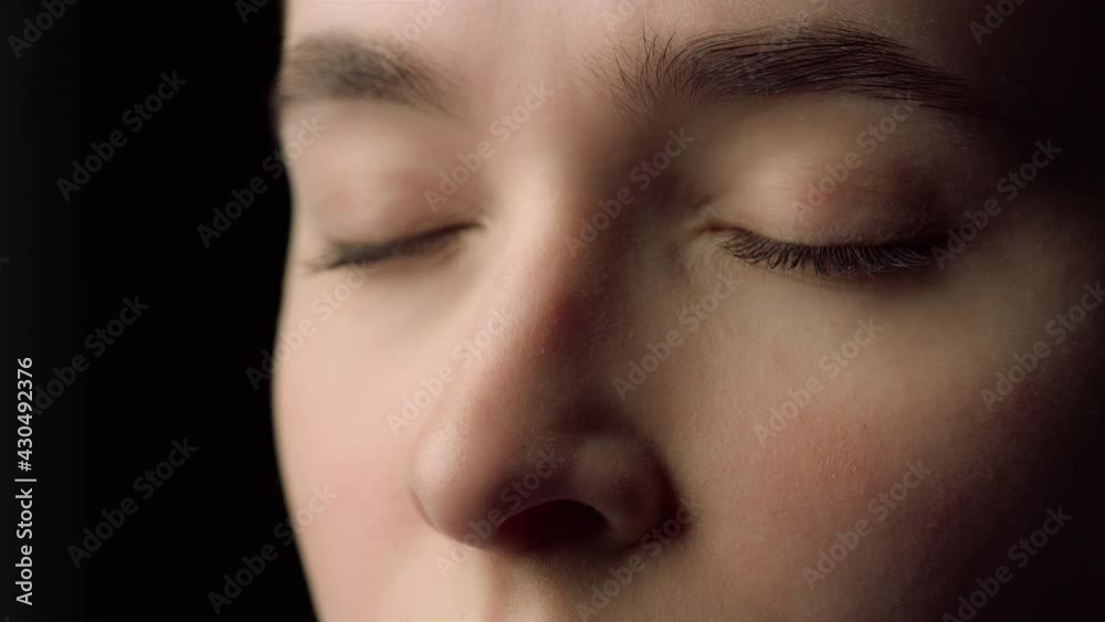 Macro of female face beauty resting with closed eyes in black studio.Tired woman Macro of female face beauty resting with closed eyes in black studio.Tired woman