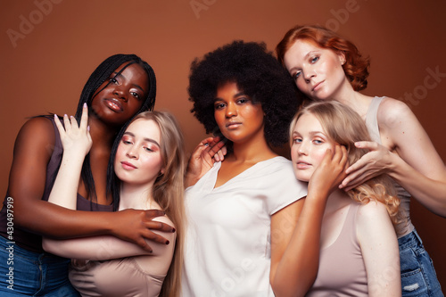 young pretty caucasian, afro, scandinavian woman posing cheerful together on brown background, lifestyle diverse nationality people concept © iordani