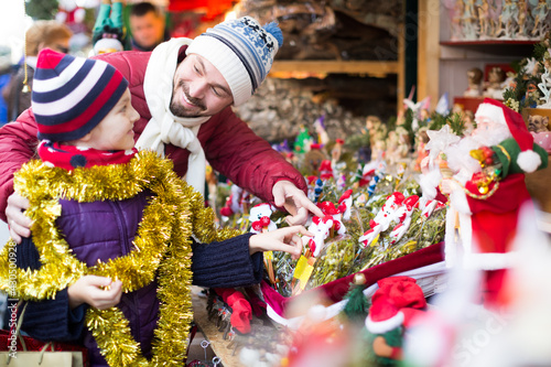 Smiling man with small daughter in Christmas market