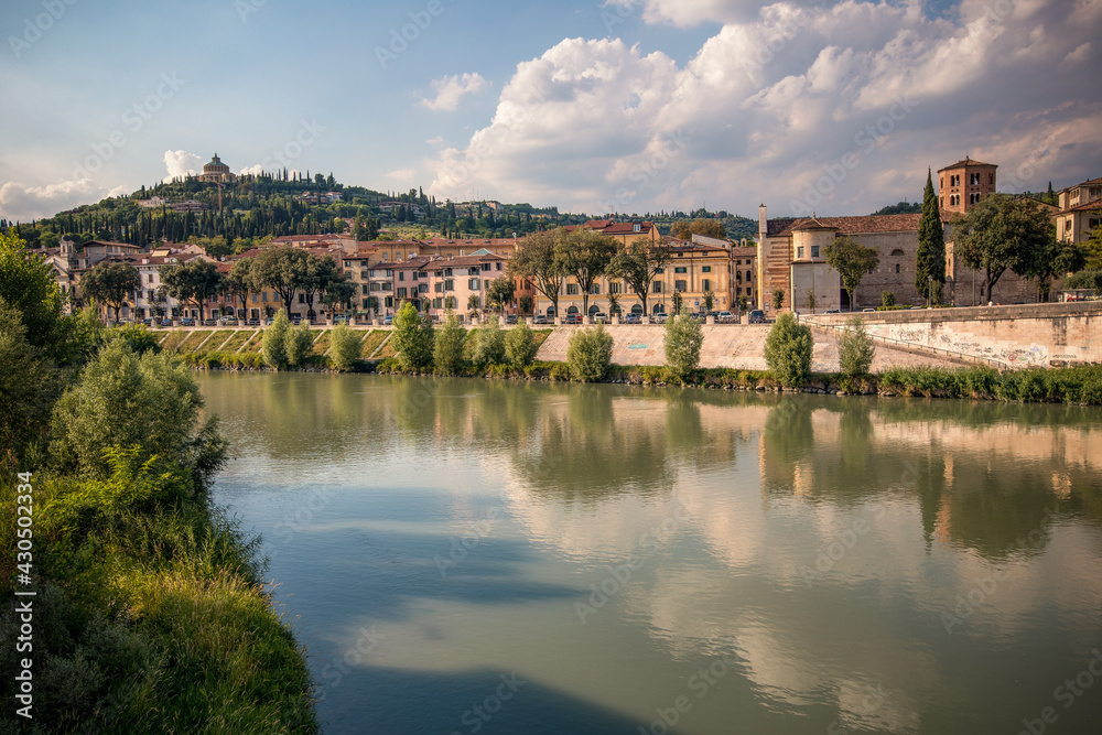 Verona, Italy, 07.04.2019: view from the bank of Adige River to Hilltop church, former fort Santuario della Nostra Signora di Lourdes