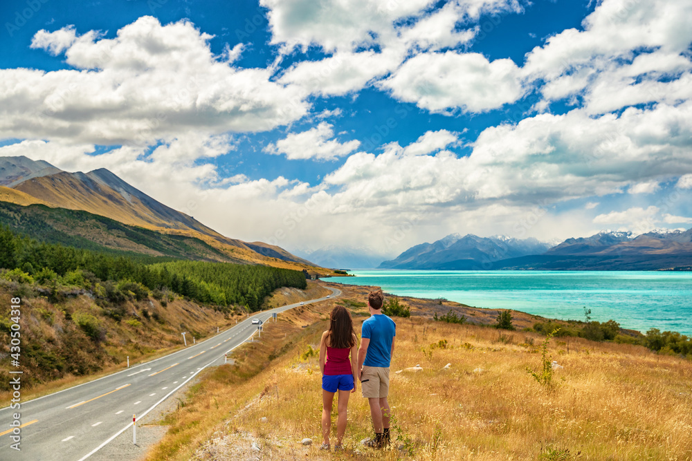 New Zealand travel - couple tourists looking at nature view of Aoraki aka Mount Cook at Peter's lookout, a famous tourist destination on New Zealand Road Trip vacation