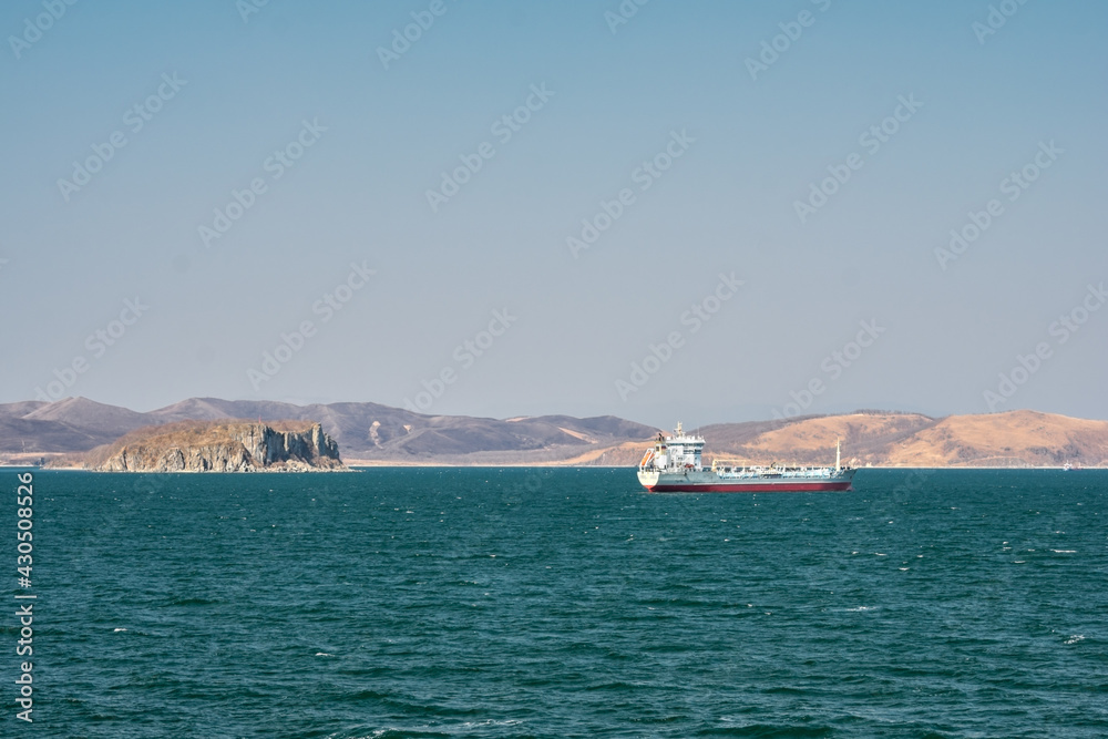 Ship in the turquoise sea against the background of autumn shores