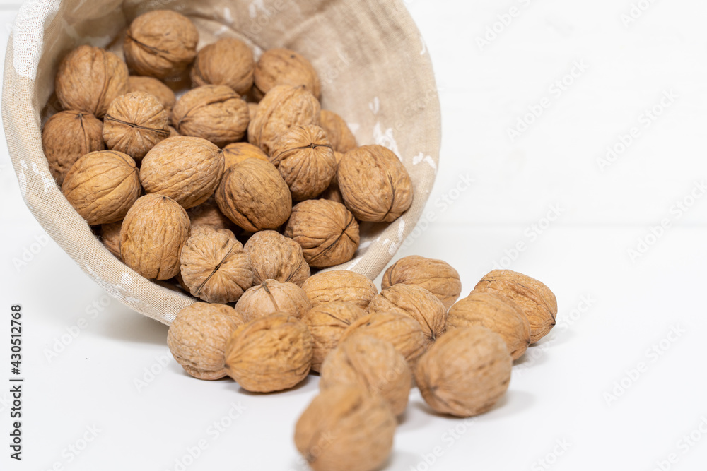 Close-up walnuts, wicker basket on white. Shallow depth of field. Close-up walnuts, wicker basket on white. Shallow depth of field.