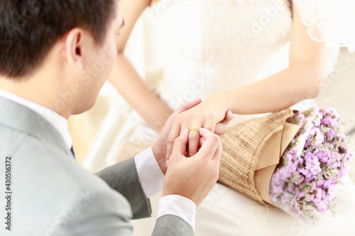 Fototapeta Naklejka Na Ścianę i Meble -  Hand of The groom wears a wedding ring to the bride