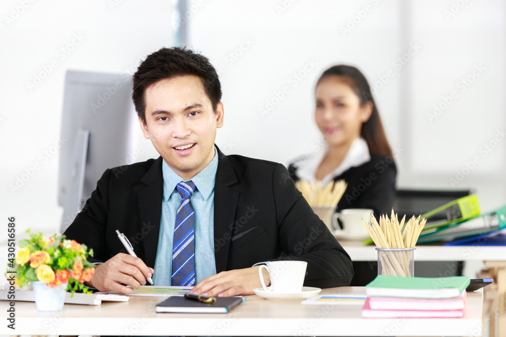 Asian businessman and businesswoman working together in office. Concept for teamwork in company Asian businessman and businesswoman working together in office. Concept for teamwork in company