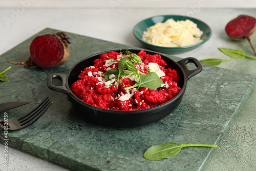 Frying pan with tasty beet risotto on table