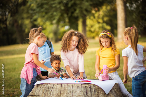 Class in nature. Large group of people writing together in the park.