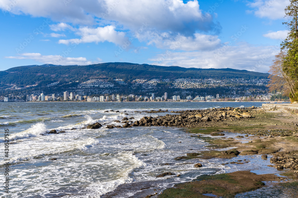 Zeus Beach, Stanley Park Seawall. West Vancouver cityscape in the background. British Columbia, Canada.