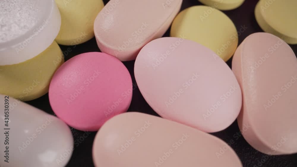 Close-up of a set of multicolored pills slowly rotating. Multicolored pills close-up. Close-up of a set of multicolored pills slowly rotating. Multicolored pills close-up.