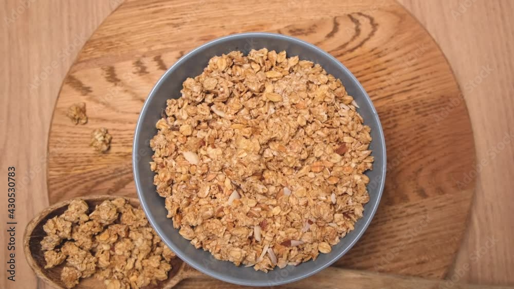 Spinning granola or oatmeal on a plate on a wooden background Spinning granola or oatmeal on a plate on a wooden background