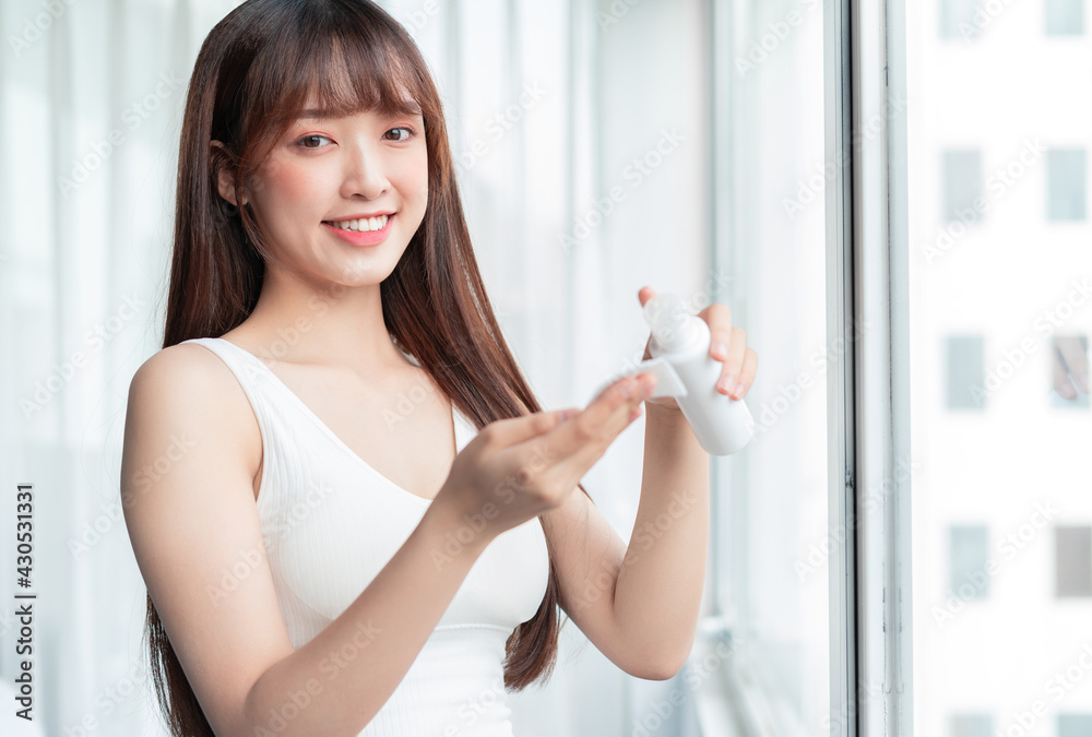 Young Asian woman was removing makeup by the window Young Asian woman was removing makeup by the window