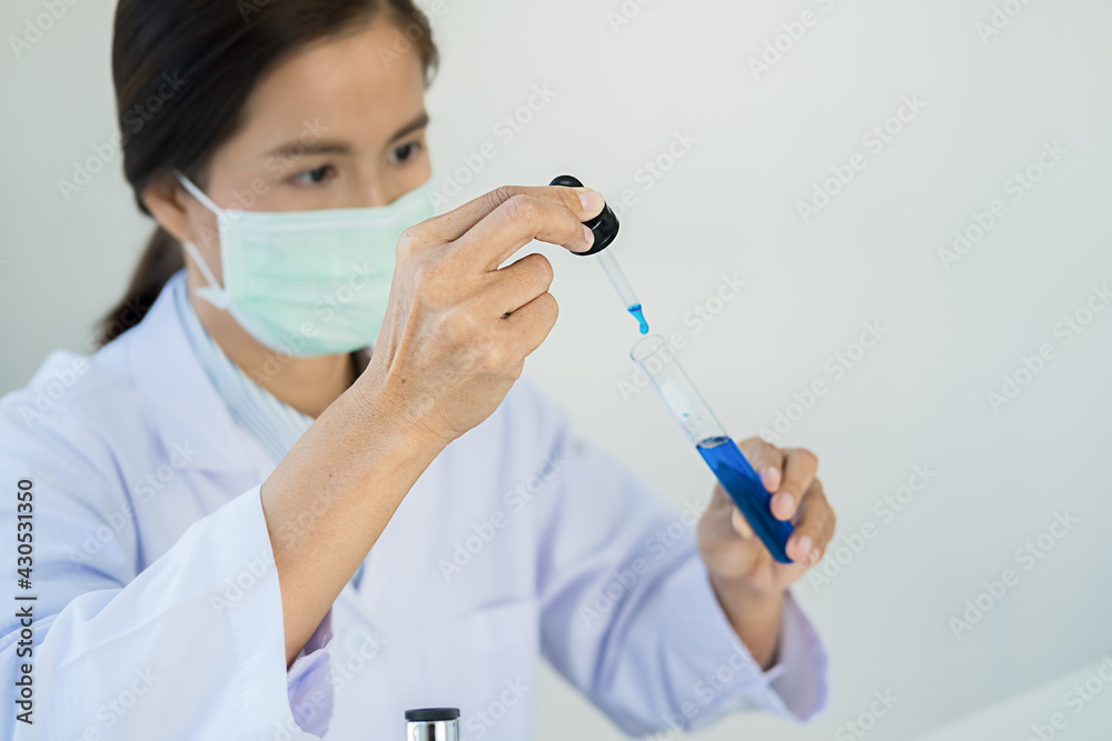 Medical or scientific researcher or man doctor looking at a test tube of clear solution in a laboratory Medical or scientific researcher or man doctor looking at a test tube of clear solution in a laboratory