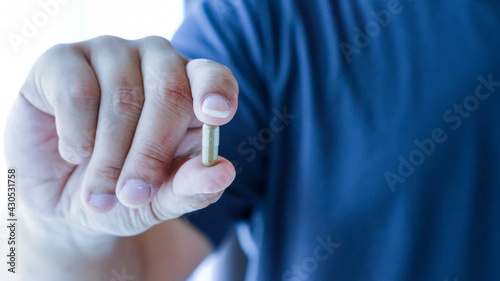 man hand holding a pills take medicine according to the doctor's order.