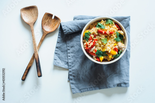 healthy lunch bowl with bulgur, chicken, sweet peppers, onion and parsley