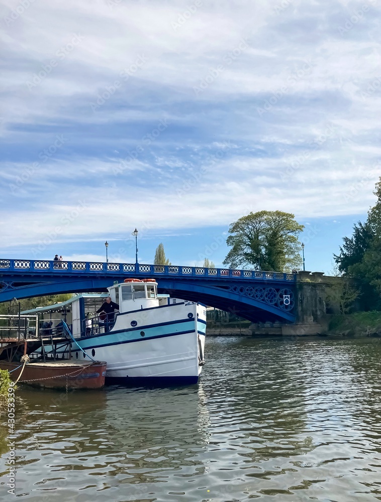 Naklejka premium Pleasure boat and a little boat on the River Severn and the bridge in the background.
