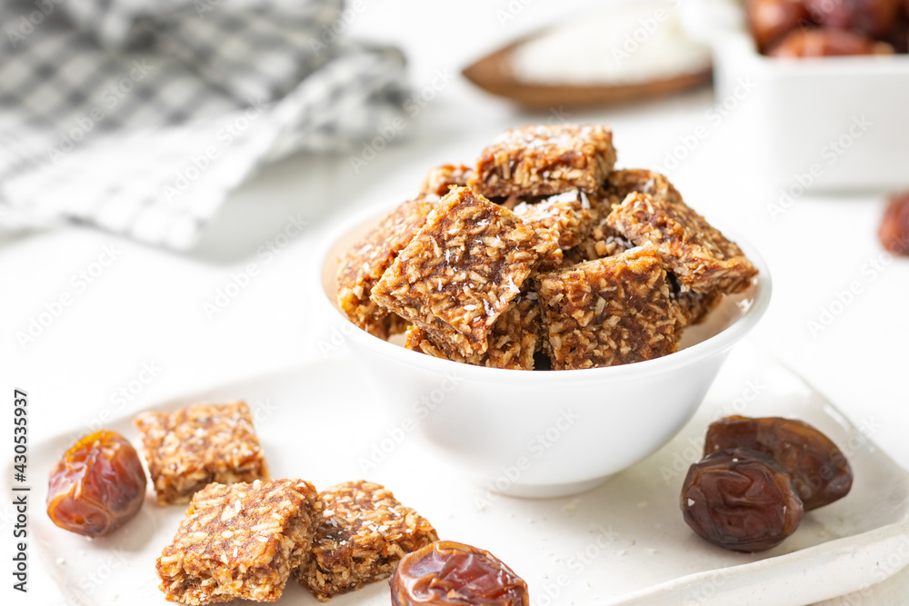 Coconut cookies with dates and carrots in a white bowl on a light background close-up. The concept of a healthy snack no sugar Coconut cookies with dates and carrots in a white bowl on a light background close-up. The concept of a healthy snack no sugar
