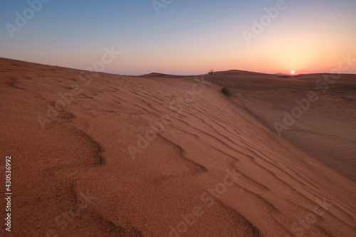 Sunset over the sand dunes in the desert.