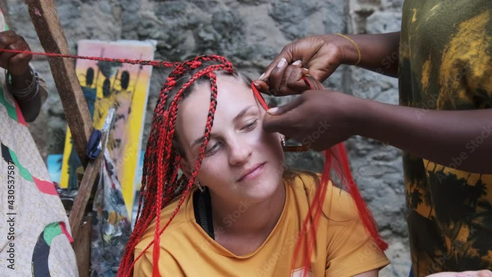 Vidéo Stock The process of weaving African braids with red kanekalon