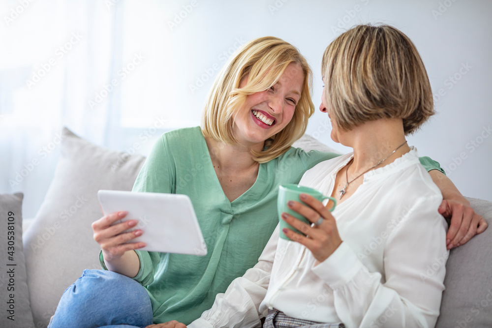 Mature Mother With Adult Daughter Relaxing On Sofa At Home. Old senior mother and young adult daughter talking bonding sit on sofa. two age generation women family chatting at home Mature Mother With Adult Daughter Relaxing On Sofa At Home. Old senior mother and young adult daughter talking bonding sit on sofa. two age generation women family chatting at home