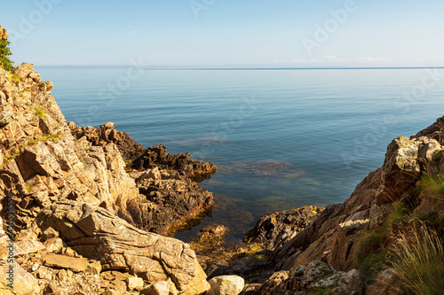 Scenic view of rocks by sea against sky