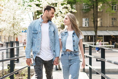 Loving couple wearing denim outfits walking during their date on a city street