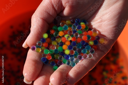 Small colorful plastic balls in the hands © leomalsam
