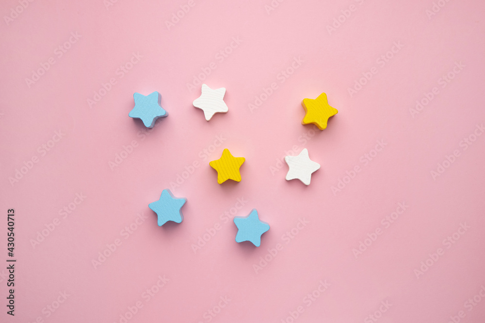Children developmental toy for the development of motor skills, a crescent wooden stars balancer, on a pink background Children developmental toy for the development of motor skills, a crescent wooden stars balancer, on a pink background