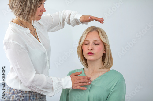 Fotografie Professional Reiki healer doing Reiki treatment to young woman in health spa center