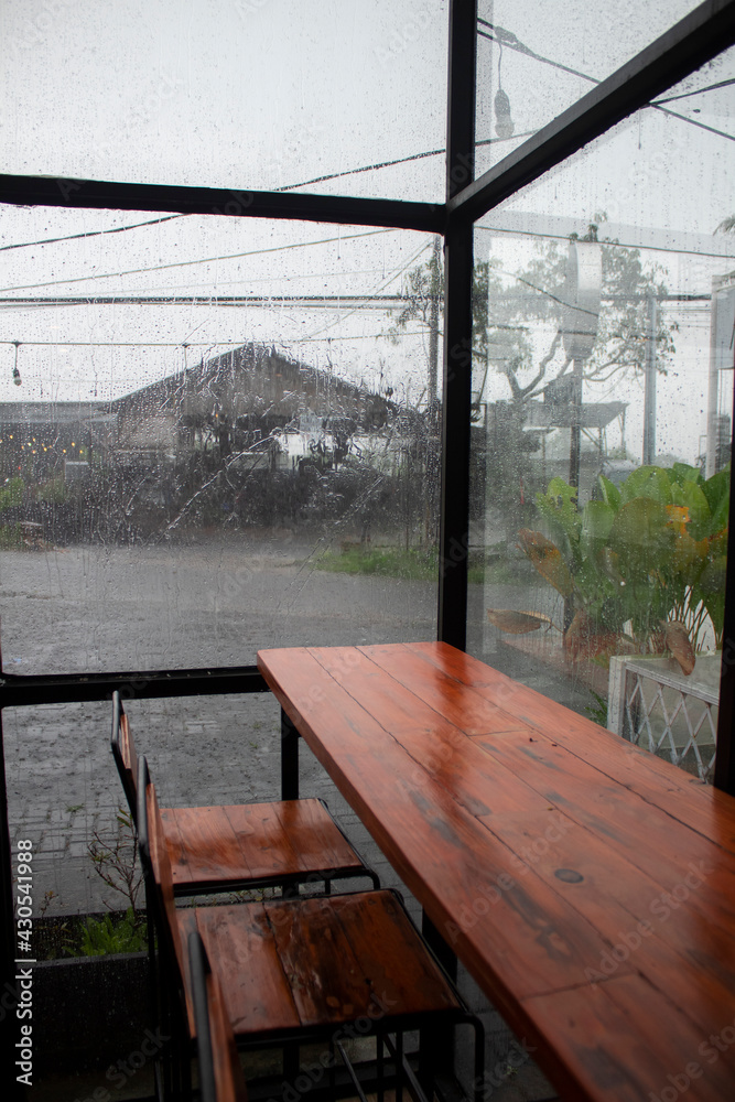 Simple bench and table design in cafe with rainy situation outside cafe